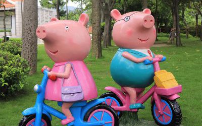 幼兒園玻璃鋼卡通騎自行車的小豬佩奇雕塑
